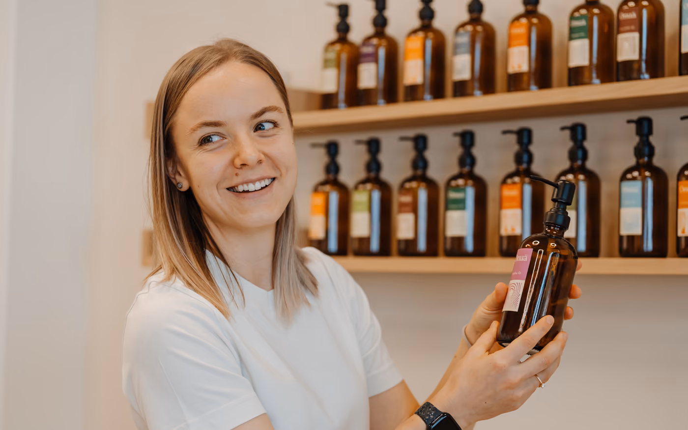 Therapist showing a massage oil at the oil wall