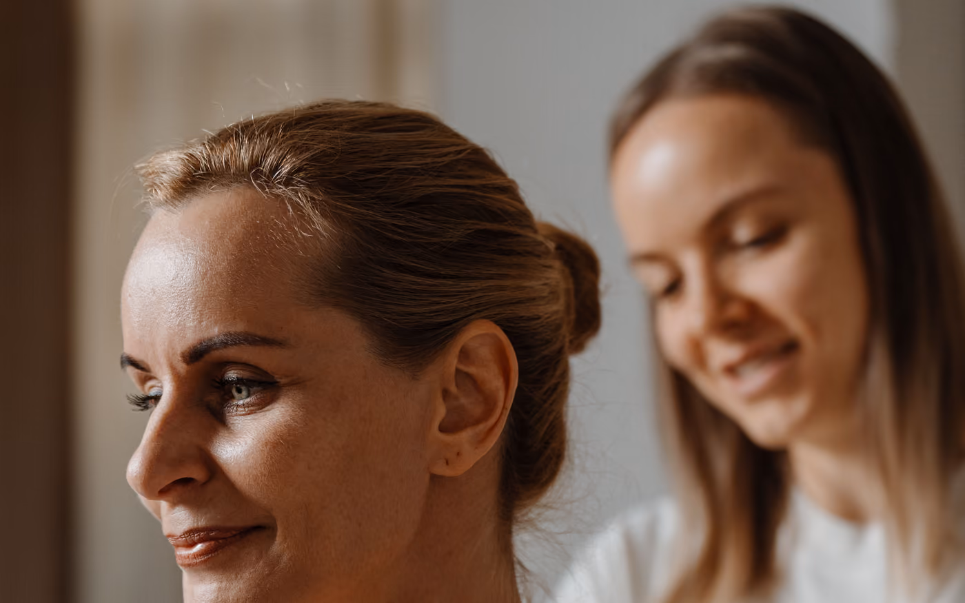 Smiling therapist checking a client’s shoulders